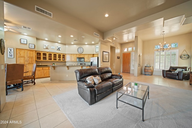 living room featuring ceiling fan with notable chandelier and light tile patterned floors