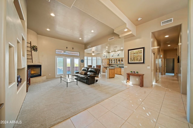 carpeted living room with ceiling fan and french doors