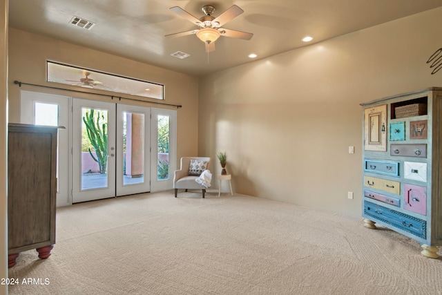 living area with french doors, light colored carpet, and ceiling fan