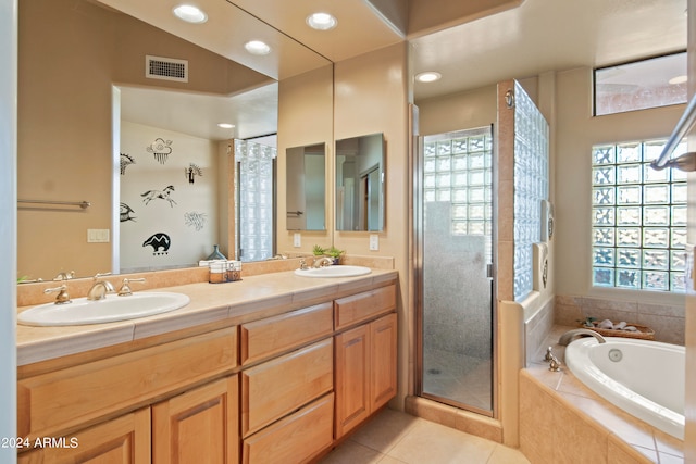 bathroom featuring independent shower and bath, vanity, and tile patterned floors