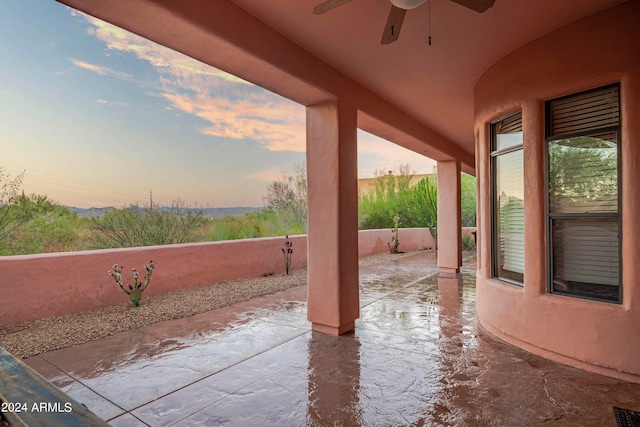 patio terrace at dusk featuring ceiling fan