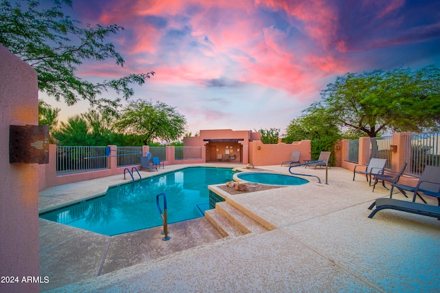 pool at dusk with a patio