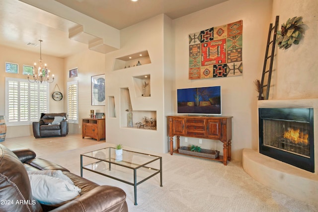 carpeted living room with a high ceiling, a large fireplace, and a notable chandelier