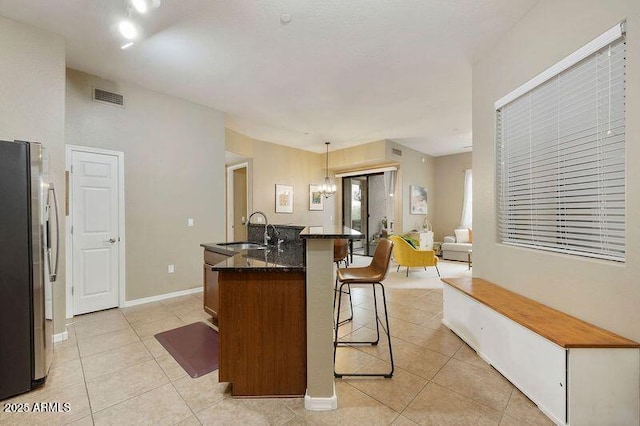 3330 S Gilbert Rd Unit 2090, Chandler, AZ 85286 - kitchen featuring visible vents, a kitchen bar, freestanding refrigerator, light tile patterned flooring, and a sink