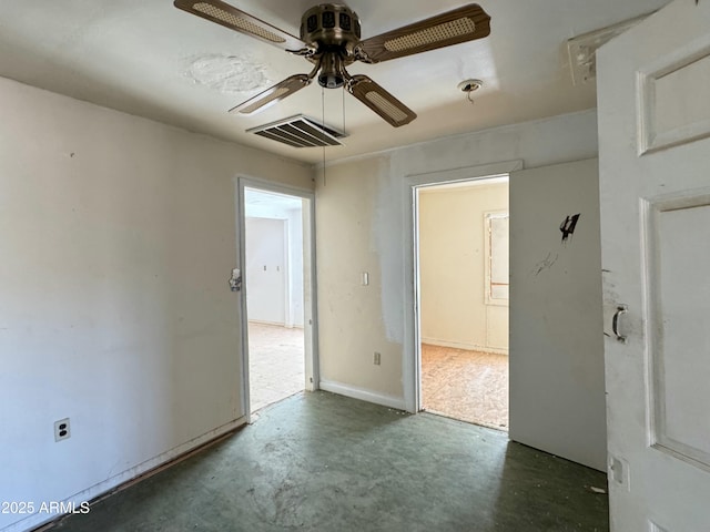 spare room with ceiling fan, concrete floors, and visible vents