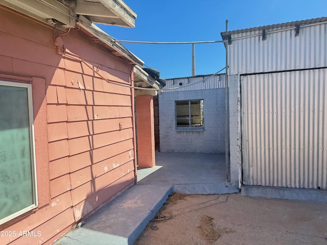 view of home's exterior with concrete block siding and a package area