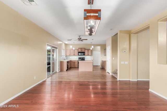 unfurnished living room featuring ceiling fan and dark hardwood / wood-style flooring