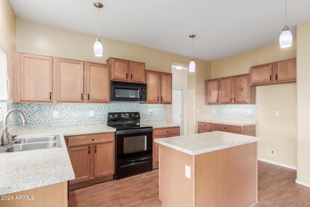 kitchen with decorative backsplash, sink, black appliances, a center island, and light hardwood / wood-style floors