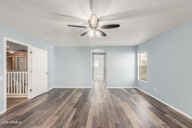 empty room with ceiling fan and dark wood-type flooring