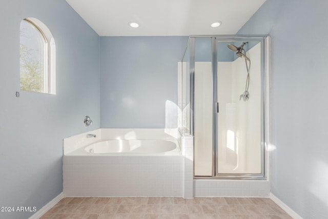 bathroom featuring shower with separate bathtub