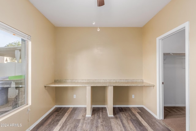 unfurnished office featuring ceiling fan and dark hardwood / wood-style floors