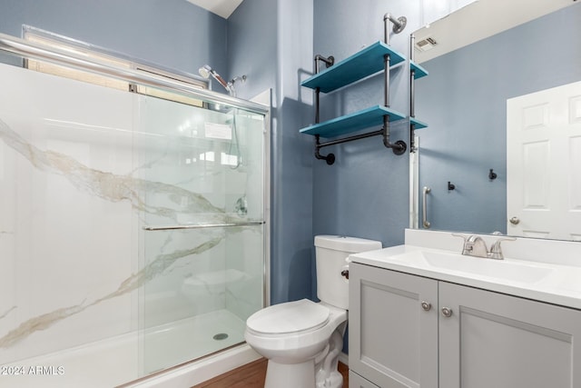 bathroom featuring hardwood / wood-style flooring, a shower with door, vanity, and toilet