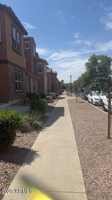 2111 N 77th Gln, Phoenix, AZ 85035 - view of road with a residential view, sidewalks, and street lighting