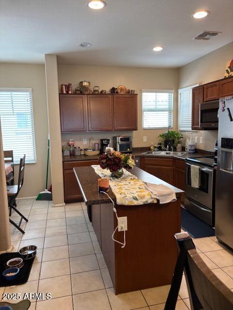 2111 N 77th Gln, Phoenix, AZ 85035 - kitchen featuring appliances with stainless steel finishes, a center island, light tile patterned floors, a sink, and recessed lighting