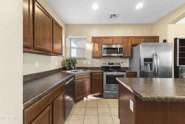 2111 N 77th Gln, Phoenix, AZ 85035 - kitchen featuring appliances with stainless steel finishes, a sink, dark countertops, light tile patterned floors, and recessed lighting