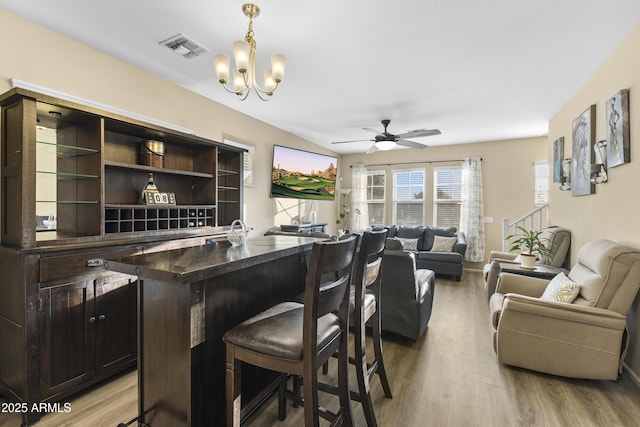 2111 N 77th Gln, Phoenix, AZ 85035 - bar area featuring light wood-style flooring, ceiling fan, hanging light fixtures, and a chandelier