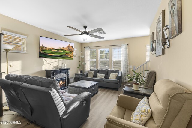 2111 N 77th Gln, Phoenix, AZ 85035 - living area with ceiling fan, light wood finished floors, and a lit fireplace