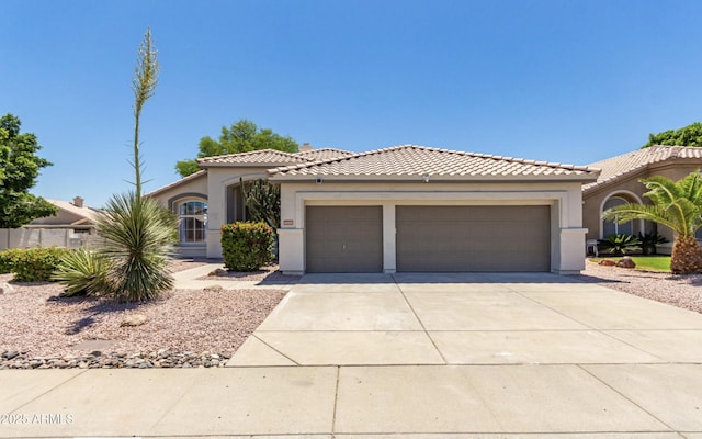 mediterranean / spanish-style house featuring a tiled roof, an attached garage, driveway, and stucco siding