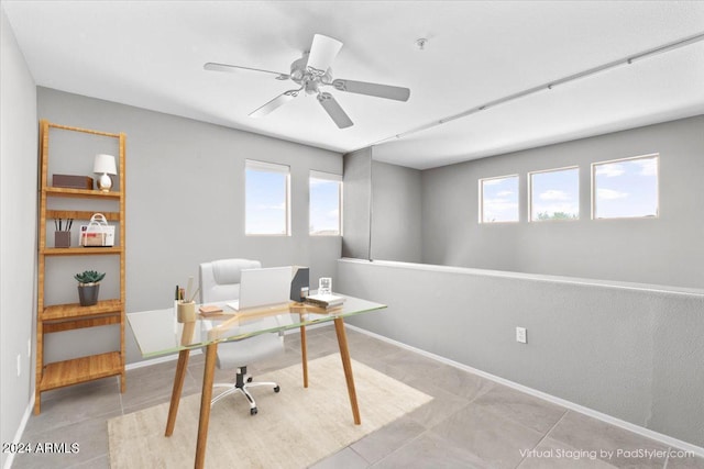 office area with a ceiling fan, a wealth of natural light, and baseboards