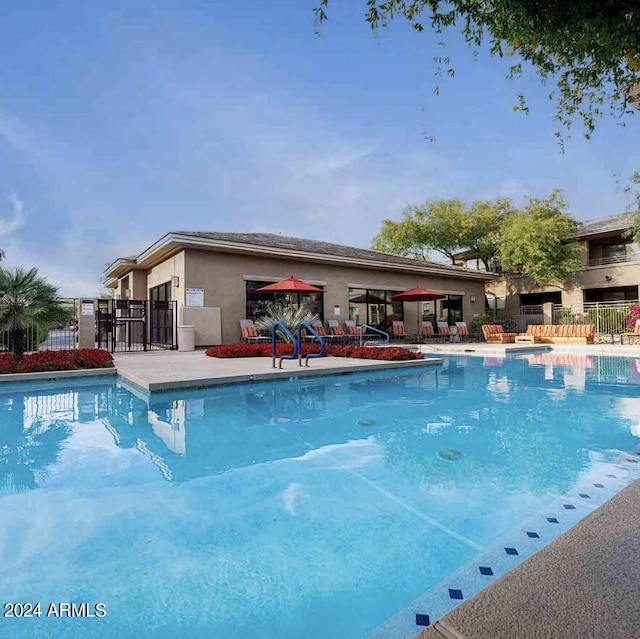 community pool featuring fence and a patio