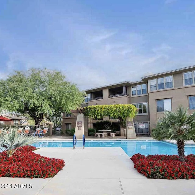 pool with a patio area and fence