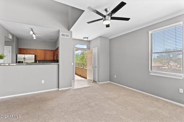 unfurnished living room featuring baseboards, ceiling fan, visible vents, and light colored carpet