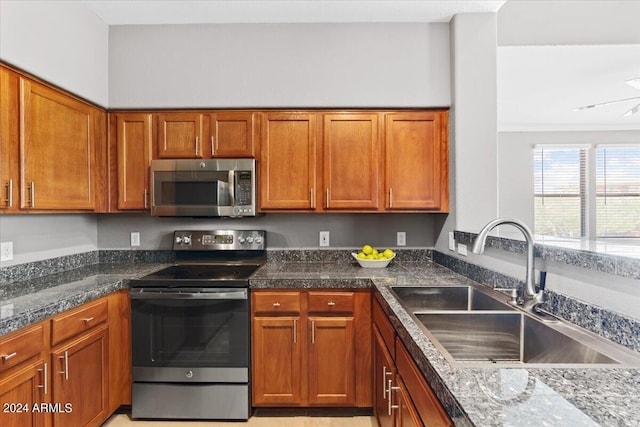 kitchen featuring stainless steel appliances, a sink, and brown cabinets