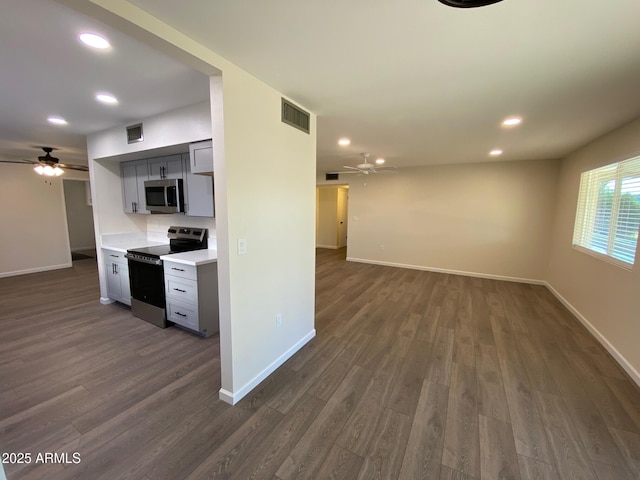 kitchen with appliances with stainless steel finishes, ceiling fan, gray cabinets, and dark hardwood / wood-style floors