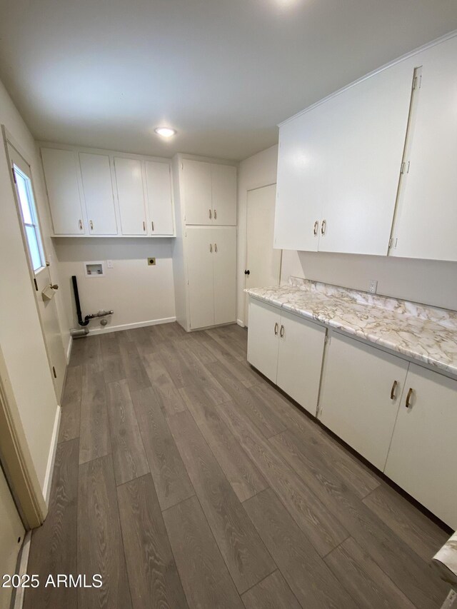 laundry room with washer hookup, cabinets, hardwood / wood-style floors, and electric dryer hookup