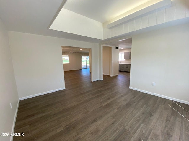 spare room featuring ceiling fan and dark wood-type flooring