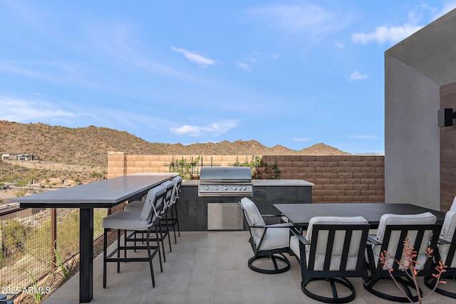 14108 E Harmony Ln, Fountain Hills, AZ 85268 - view of patio with fence, area for grilling, outdoor wet bar, a mountain view, and an outdoor kitchen
