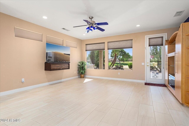 spare room featuring ceiling fan, a healthy amount of sunlight, and light hardwood / wood-style floors