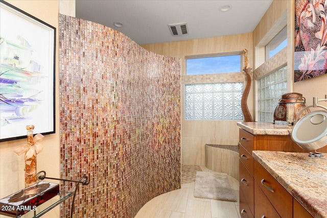 bathroom with tile patterned floors, vanity, and walk in shower