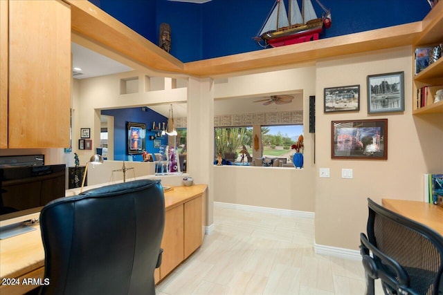 office area featuring a towering ceiling and ceiling fan