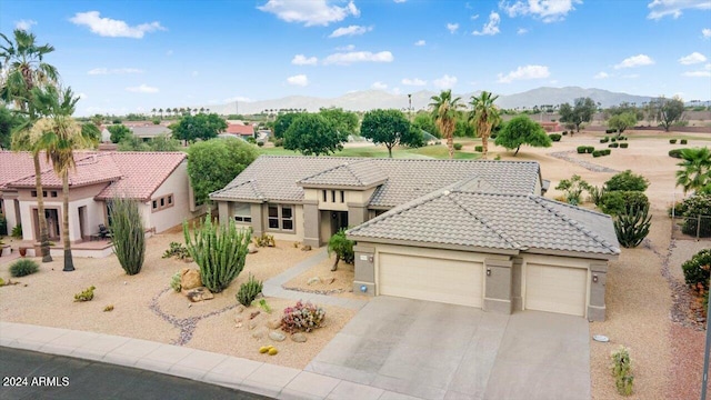 view of front of home with a mountain view and a garage