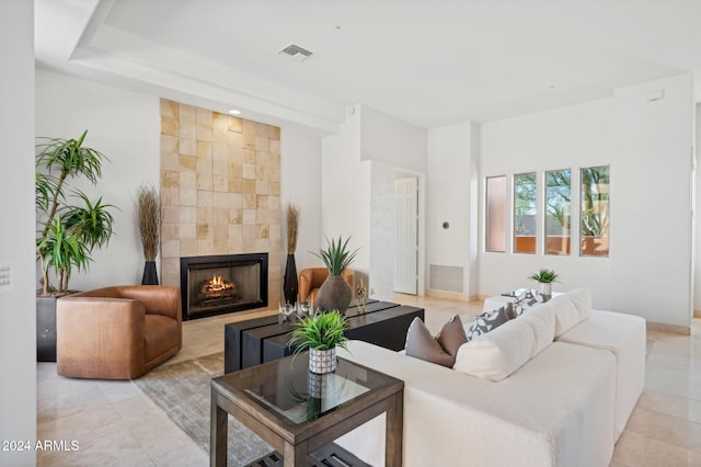 living room with a fireplace and light tile patterned floors