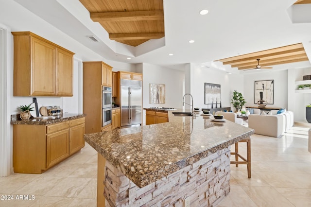 kitchen featuring beam ceiling, a spacious island, sink, and stainless steel appliances