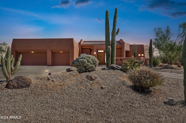 pueblo-style house featuring a garage