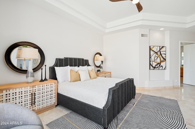 bedroom with a raised ceiling and ceiling fan