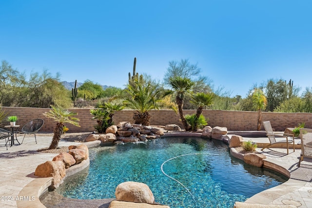 view of pool with pool water feature and a patio