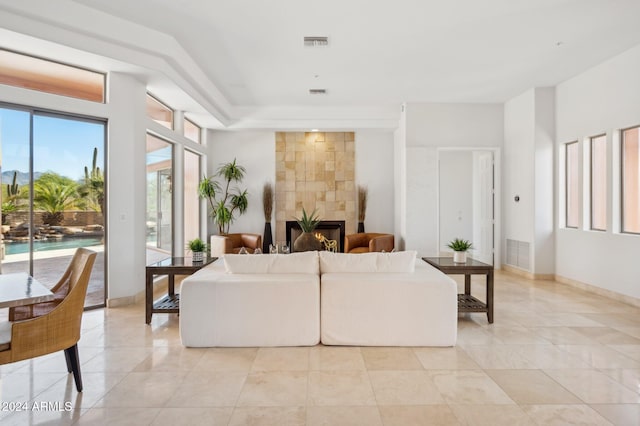 living room with a fireplace and light tile patterned floors