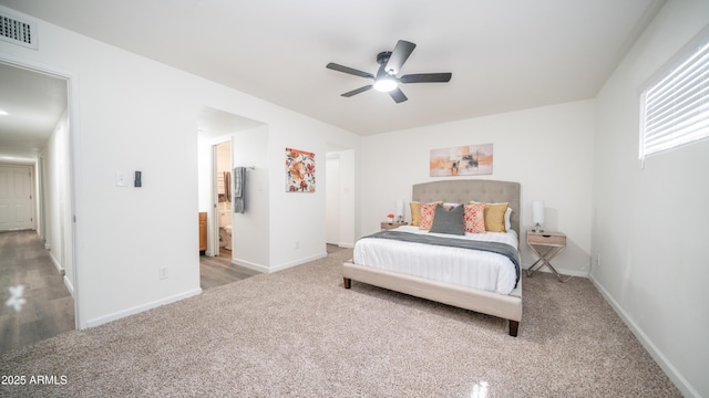 carpeted bedroom featuring connected bathroom, visible vents, baseboards, and ceiling fan