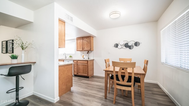 dining area featuring visible vents, baseboards, and wood finished floors