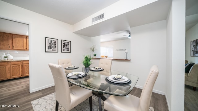 dining area with visible vents, baseboards, wood finished floors, and a ceiling fan