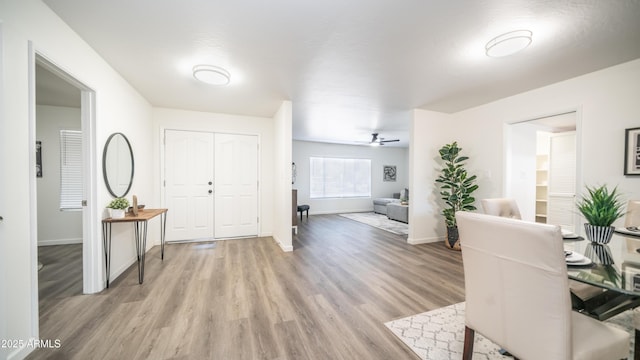 entrance foyer featuring light wood-type flooring, baseboards, and a ceiling fan