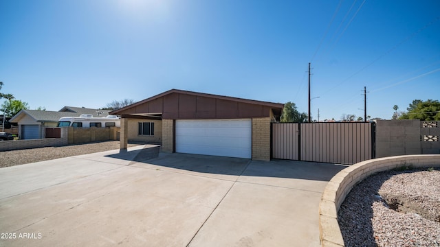 exterior space with brick siding, board and batten siding, fence, a garage, and driveway