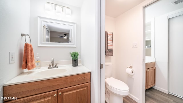 bathroom featuring vanity, toilet, wood finished floors, and visible vents