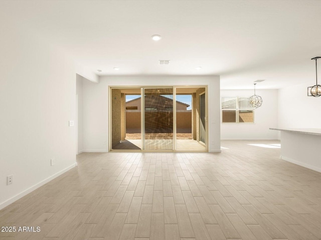 unfurnished room with a notable chandelier