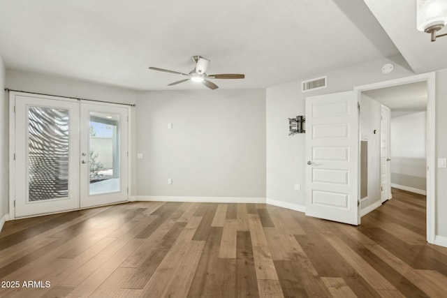 spare room featuring dark wood-type flooring, french doors, and ceiling fan