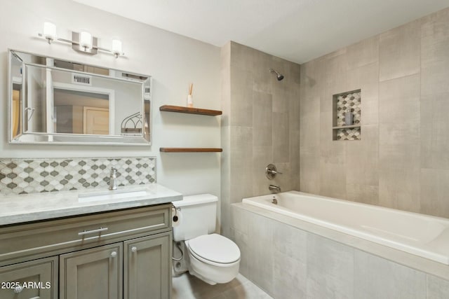 full bathroom with tiled shower / bath, vanity, toilet, and backsplash